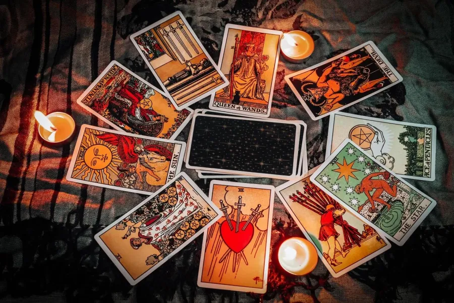 Tarot spread arranged in a circle with tea lights glowing nearby